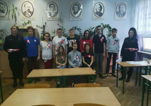 Uczniowie klasy 1 a Liceum Ogólnokształcącego prezentują swoje kokardy narodowe