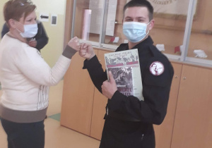 Uczeń z klasy mundurowej odbiera dyplom z rąk dyrektor szkoły.