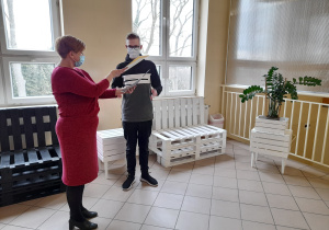Dyrektor szkoły wręcza stypendium uczniowi.
