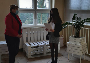 Dyrektor szkoły wręcza stypendium uczennicy.