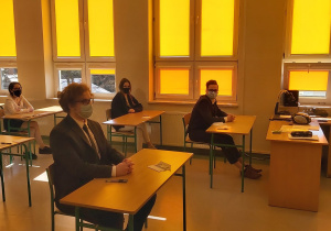 Uczniowie w ławkach w oczekiwaniu na rozpoczęcie matur.