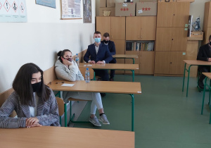 Uczniowie w ławkach w oczekiwaniu na rozpoczęcie matur.