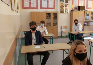 Uczniowie w ławkach w oczekiwaniu na rozpoczęcie matur.