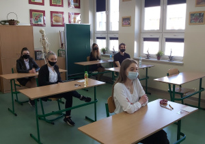 Uczniowie w ławkach w oczekiwaniu na rozpoczęcie matur.