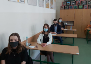 Uczniowie w ławkach w oczekiwaniu na rozpoczęcie matur.