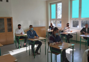 Uczniowie w ławkach w oczekiwaniu na rozpoczęcie matur.