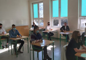 Uczniowie w ławkach w oczekiwaniu na rozpoczęcie matur.