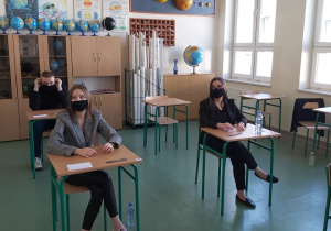Uczniowie w ławkach w oczekiwaniu na rozpoczęcie matur.