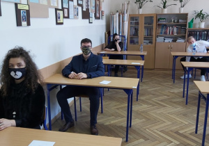 Uczniowie w ławkach w oczekiwaniu na rozpoczęcie matur.