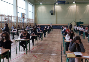 Uczniowie w ławkach w oczekiwaniu na rozpoczęcie matur.
