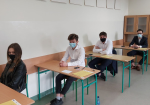 Uczniowie w ławkach w oczekiwaniu na rozpoczęcie matur.