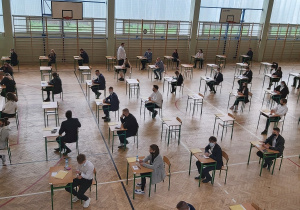 Uczniowie w ławkach w oczekiwaniu na rozpoczęcie matur.