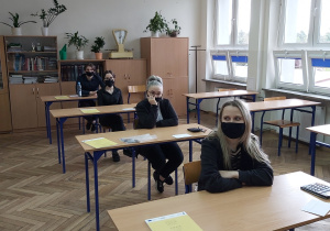 Uczniowie w ławkach w oczekiwaniu na rozpoczęcie matur.