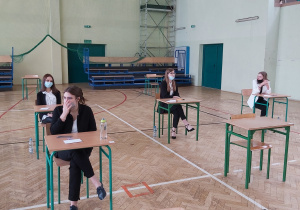 Uczniowie w ławkach w oczekiwaniu na rozpoczęcie matur.
