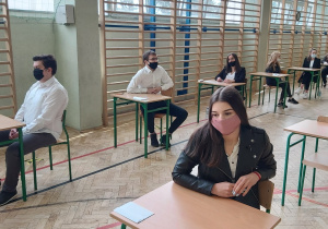 Uczniowie w ławkach w oczekiwaniu na rozpoczęcie matur.