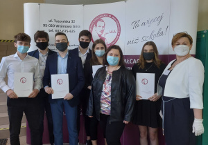 Dyrektor szkoły i wychowawca klasy z absolwentami.