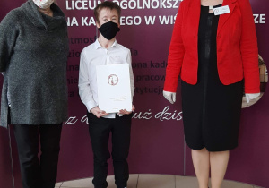 Dyrektor szkoły i wychowawca z absolwentem.