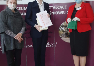Dyrektor szkoły i wychowawca z absolwentem.
