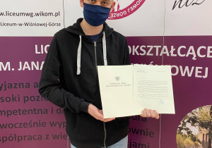 Uczeń z listem gratulacyjnym.