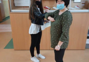 Uczennica przyjmuje gratulacje z rąk wychowawcy klasy.