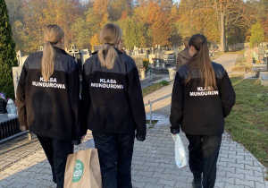 Wolontariusze Karskiego porządkują groby na cmentarzu w Bedoniu