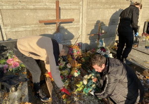 Wolontariusze Karskiego porządkują groby na cmentarzu w Bedoniu