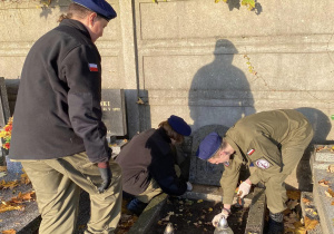 Wolontariusze Karskiego porządkują groby na cmentarzu w Bedoniu