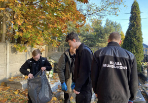 Wolontariusze Karskiego porządkują groby na cmentarzu w Bedoniu
