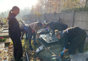 Wolontariusze Karskiego porządkują groby na cmentarzu w Bedoniu