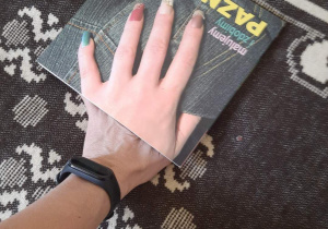 Dłoń położona na książce.
